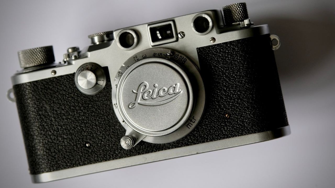 Câmera Leica antiga sobre superfície branca, ilustrando artigo Câmeras Leica hoje.