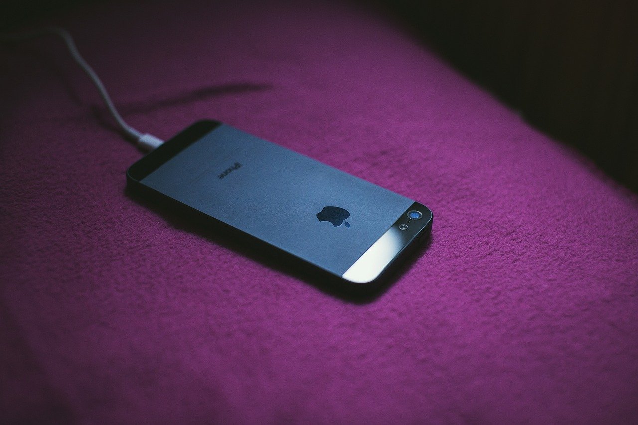 iPhone conectado ao carregador, imagem ilustrativa sobre carregar celular até 80% para preservar a bateria.